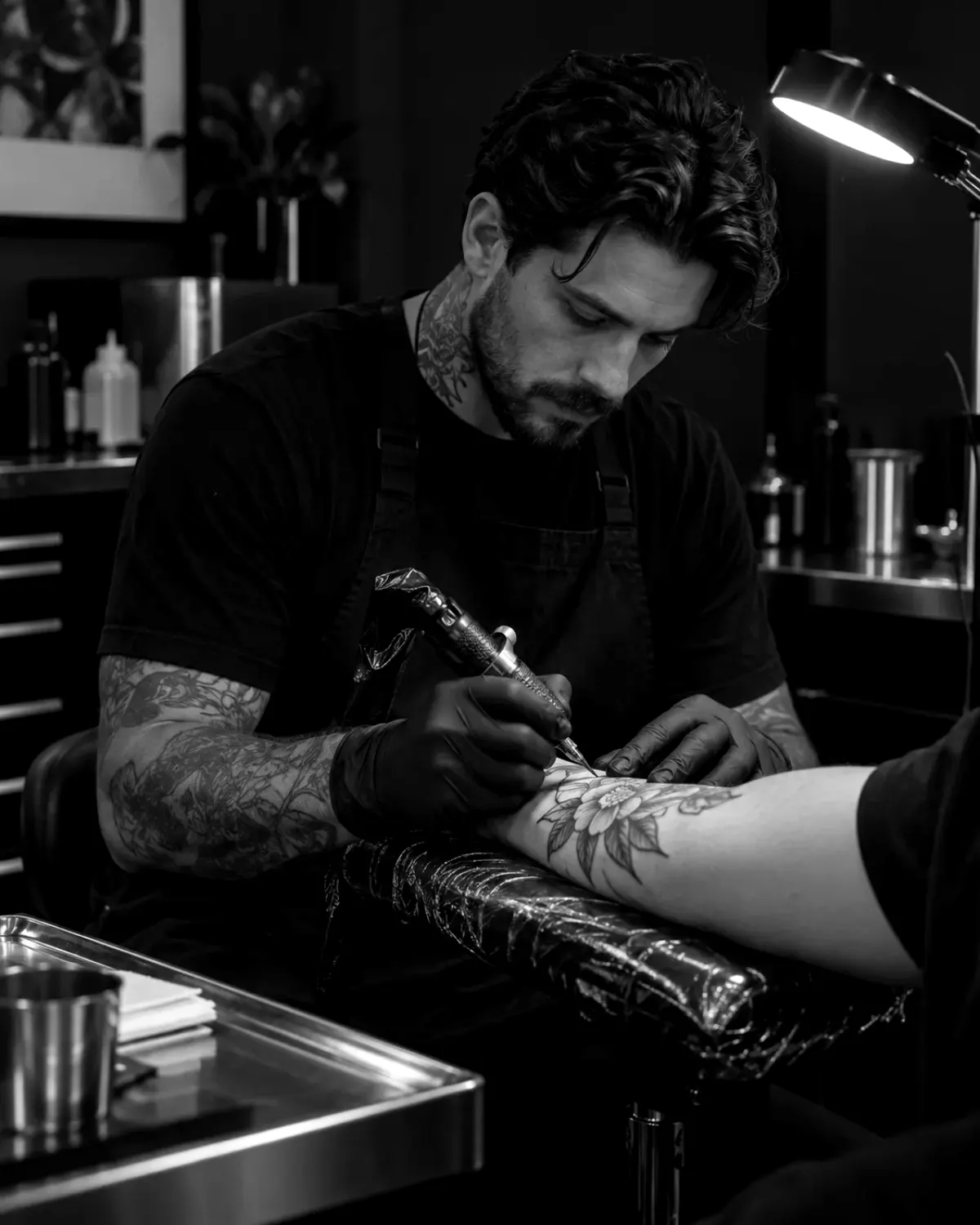 Tatuador trabalhando com atenção em um estúdio contemporâneo